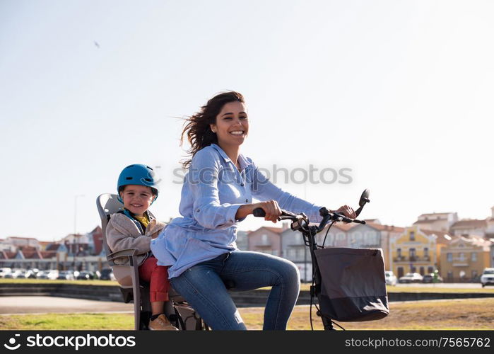 Eco-friendly Family. Mother riding on a bicycle with young kid