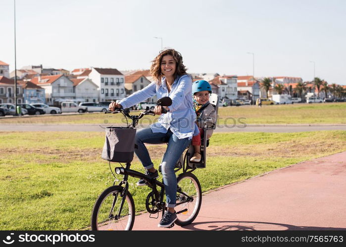 Eco-friendly Family. Mother riding on a bicycle with young kid