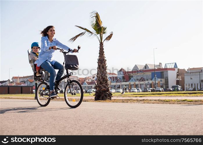 Eco-friendly Family. Mother riding on a bicycle with young kid