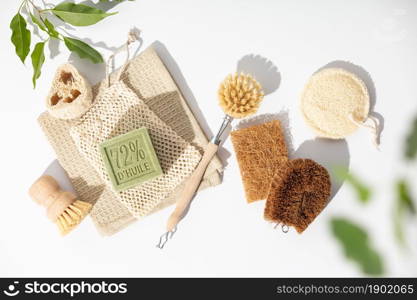 Eco friendly natural cleaning tools and products, bamboo and coconut dish brushes, luffa loofah sponges, baking soda and solid soap on white background. Zero waste concept. Plastic free. Flat lay, top view