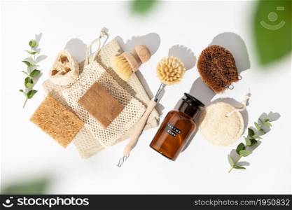 Eco friendly natural cleaning tools and products, bamboo and coconut dish brushes, luffa loofah sponges, baking soda and solid soap on white background. Zero waste concept. Plastic free. Flat lay, top view