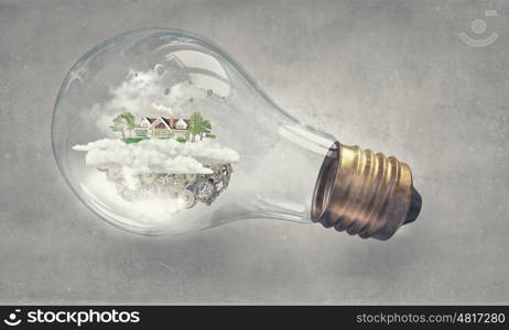 Eco life. Eco house and energy saving concept in glass light bulb