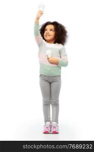 eco living and sustainability concept - smiling african american girl comparing energy saving light bulb with incandescent l&over white background. african american girl with different light bulbs