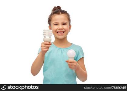 eco living and sustainability concept - smiling girl comparing energy saving light bulb with incandescent l&over white background. smiling girl comparing different light bulbs