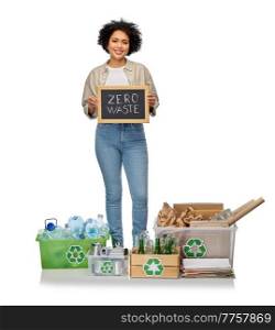 eco living, environment and sustainability concept - happy smiling woman holding chalkboard with zero waste words and plastic, glass paper, metal garbage in boxes over white background. happy woman with zero waste words on chalkboard