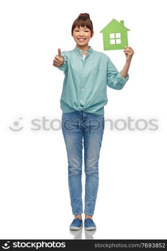 eco living, environment and sustainability concept - happy smiling young asian woman in turquoise shirt holding green house showing thumbs up over white background. asian woman with green house showing thumbs up