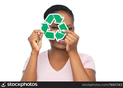 eco living, environment and sustainability concept - portrait of happy smiling young african american woman looking through green recycling sign over white background. smiling asian woman holding green recycling sign