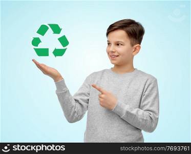 eco living, environment and sustainability concept - smiling boy showing green recycling sign over blue background. smiling boy showing green recycling sign