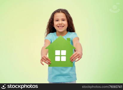 eco living, environment and sustainability concept - smiling little girl holding house icon over green background. smiling little girl holding green house icon
