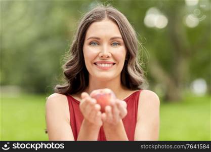 eco living, healthy eating and people concept - portrait of happy woman with peach at summer park. happy woman eating peach at summer park