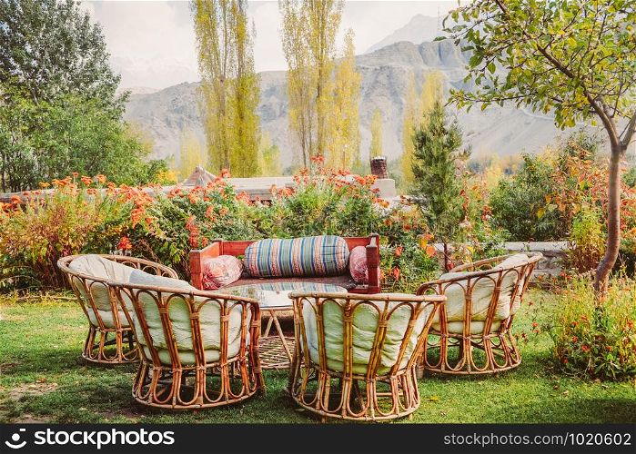 Eco living style garden with local wooden furniture surrounded by beautiful flowers and trees in Shigar. Gilgit Baltistan, Pakistan.
