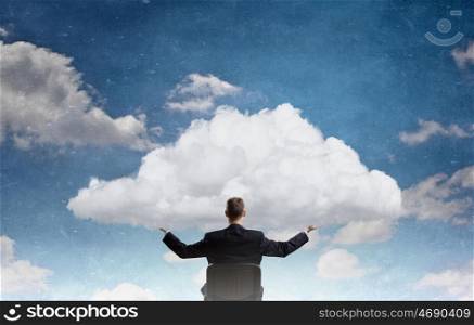 Eco or cloud computing. Back view of businessman in chair holding white cloud