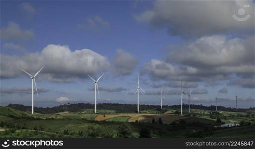 Eco power, landscape with hills and wind turbine field on blue sky background.
