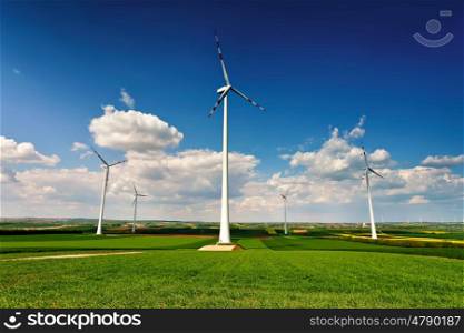 Eco power. Wind turbines generating electricity. Green environment. Spring sunny day on green field with wind power generators in Austria