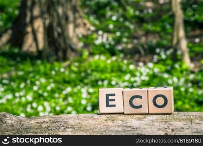 Eco sign on a wooden branch in the forest