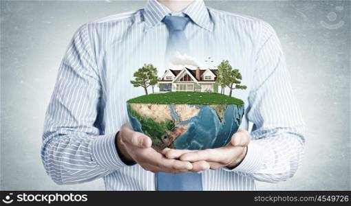 Ecologically healthy. Close up of hands presenting model of green countryside life. Elements of this image are furnished by NASA