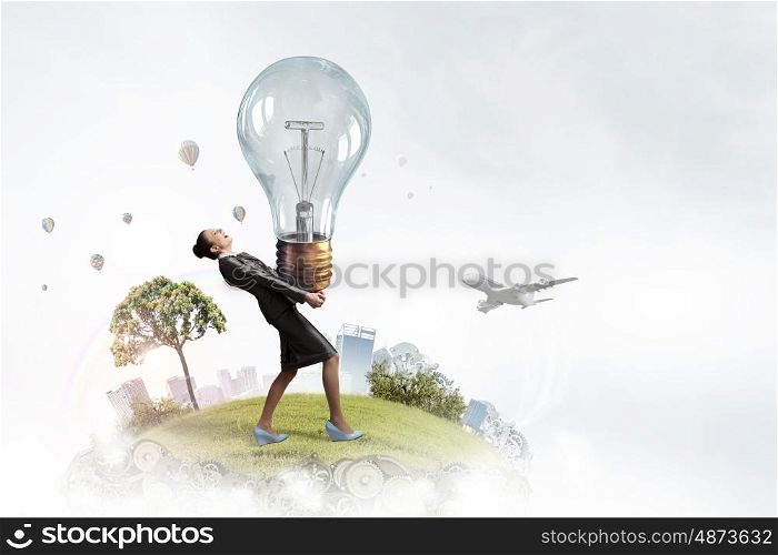 Ecology and energy saving. Young businesswoman carrying glass glowing light bulb in hands