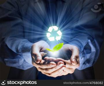 Ecology concept. Green sprout in human hands. Recycle idea