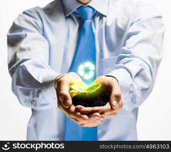 Ecology concept. Green sprout in human hands. Recycle idea