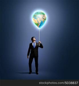 |Ecology concept. Image of businessman in goggles holding globe. Protect planet. Elements of this image are furnished by NASA