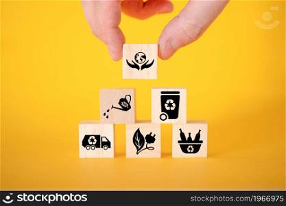 Ecology concept with icons on wooden cubes, yellow background. The concept of clean energy for the whole world.. Ecology concept with icons on wooden cubes, yellow background.
