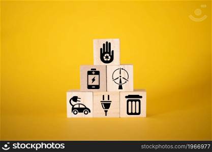 Ecology concept with icons on wooden cubes, yellow background. The concept of clean energy for the whole world.. Ecology concept with icons on wooden cubes, yellow background.