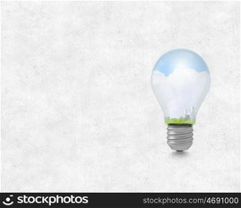 Ecology concept with light bulb and city inside. Electric green energy