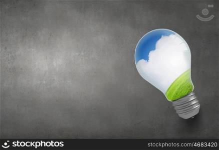 Ecology concept with light bulb and rainbow inside. Green light bulb