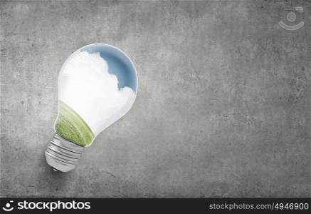 Ecology concept with light bulb and rainbow inside. Green light bulb
