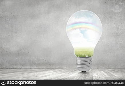 Ecology concept with light bulb and rainbow inside. Green light bulb