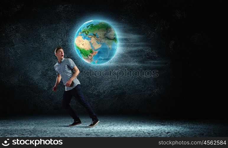 Ecology concept. Young man against dark running from Earth planet. Elements of this image are furnished by NASA