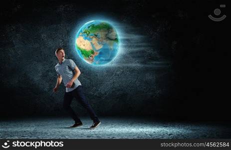 Ecology concept. Young man against dark running from Earth planet. Elements of this image are furnished by NASA