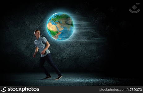 Ecology concept. Young man against dark running from Earth planet. Elements of this image are furnished by NASA