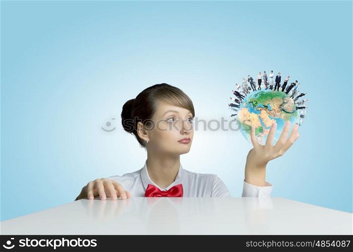 Ecology concept. Young smiling woman holding balloon colored like Earth planet. Elements of this image are furnished by NASA