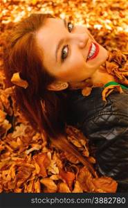Ecology earth, eco friendly and love nature concept. Portrait young redhaired woman lying in autumn orange leaves.