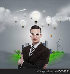Ecology ideas concept. Businessman standing in front of cityscape with light bulb overhead