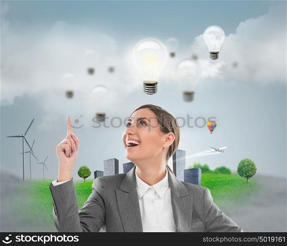 Ecology ideas concept. Businesswoman standing in front of cityscape with lamp overhead