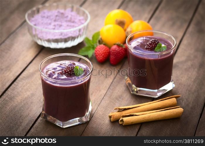 Ecuadorian traditional thick drink called Colada Morada, prepared by cooking purple corn flour and different fuits (for example strawberry, pineapple, naranjilla, grape, babaco, blackberry, etc) and seasoned with panela (cane sugar), cinnamon, allspice and cloves (Selective Focus, Focus on the blackberry on the left drink)