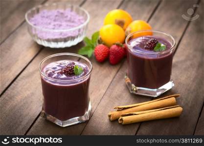 Ecuadorian traditional thick drink called Colada Morada, prepared by cooking purple corn flour and different fuits (for example strawberry, pineapple, naranjilla, grape, babaco, blackberry, etc) and seasoned with panela (cane sugar), cinnamon, allspice and cloves (Selective Focus, Focus on the blackberry on the left drink)