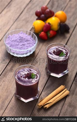 Ecuadorian traditional thick drink called Colada Morada, prepared by cooking purple corn flour and different fruits (for example strawberry, pineapple, naranjilla, grape, babaco, blackberry, etc) and seasoned with panela (cane sugar), cinnamon, allspice and cloves (Selective Focus, Focus on the blackberry on the first drink)