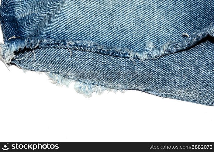 Edge of blue jeans fabric with fringe on white background.