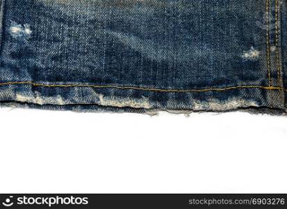 Edge of blue jeans fabric with fringe on white background.