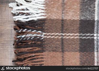Edge of fluffy checkered wool plaid with fringe