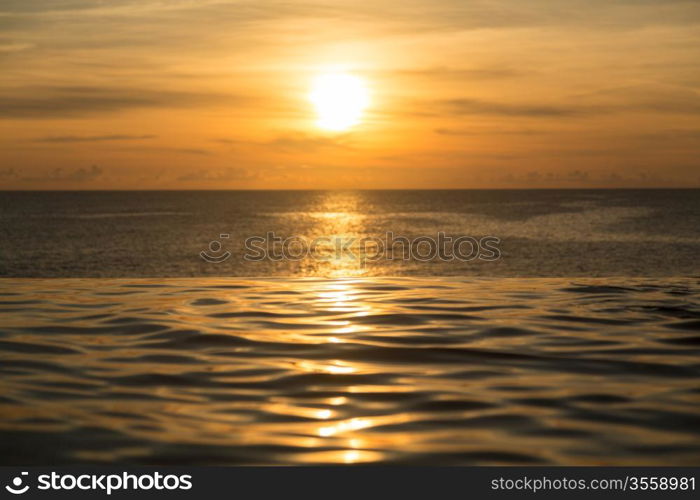 Edge of infinity swimming pool overlooking ocean at sunset