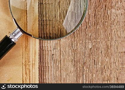 edge of the old newspaper and magnifying glass on a wooden background