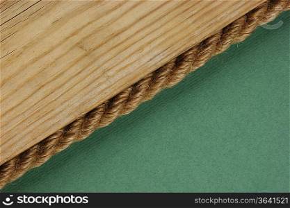 edge of the old wooden planks with rope on the green background