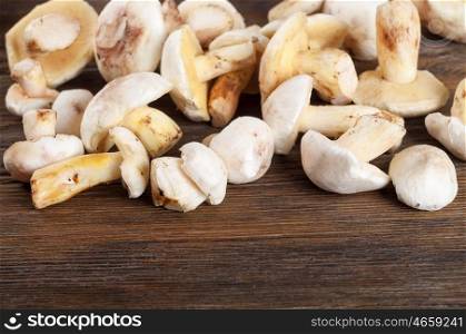 Edible wild mushrooms on a wooden background. Forest cleaned mushrooms.