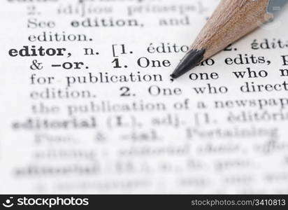 Editor in English Dictionary.. Shallow DOF, focus on editor and nib of pencil.