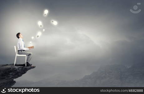 Education advantage. Businessman sitting in chair and reading book