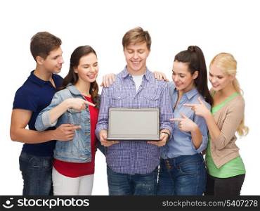 education, advertisement and new technology concept - smiling students with laptop computer blank screen